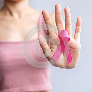 Pink October Breast Cancer Awareness month, woman hand hold pink Ribbon and wear shirt for support people life and illness.