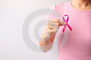 Pink October Breast Cancer Awareness month, woman hand hold pink Ribbon and wear shirt for support people life and illness.