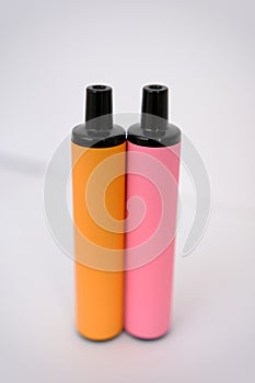 pink and orange disposable electronic cigarettes on white background. Copy space