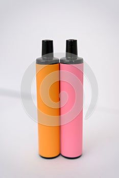 pink and orange disposable electronic cigarettes on white background. Copy space