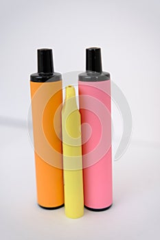 pink, orange and little yellow disposable electronic cigarettes on white background. Copy space