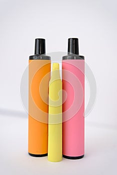 pink, orange and little yellow disposable electronic cigarettes on white background. Copy space