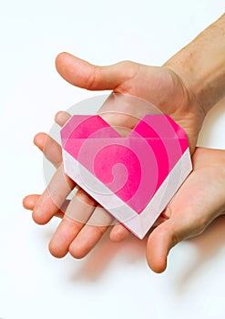 Pink origami heart in men`s hands