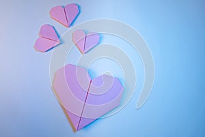 Pink origami hearts on a blue background