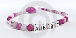 A pink pacifier chain for girls with name Abby