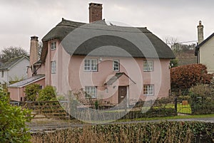 Pink painted thatched house in the winter