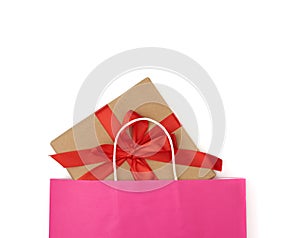 Pink paper bag with a gift box on a white background
