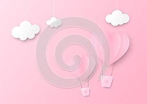 Pink paper heart shape balloon floating in the sky with three clouds hang on top