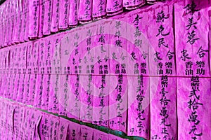 Pink paper prayer flags or slips with names in Chinese black ink in the Thien Hau Temple of Cho Lon, district 5, Saigon, Vietnam