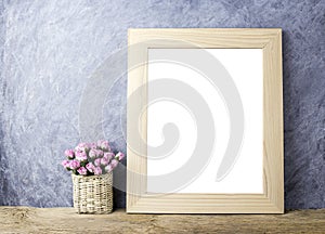 Pink paper rose flowers in basket and blank picture frame