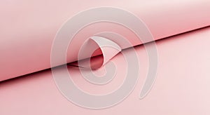 Pink paper with a slightly curled corner on a pink surface. The paper is smooth and untextured,