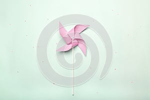 Pink paper spinner on blue background. Kids toy colorful pinwheel, carnival decoration on celebration party background