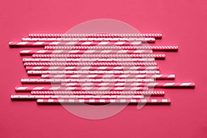 Pink paper straws on bright magenta background.