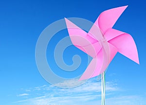 Pink paper windmill in the sky