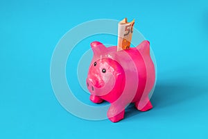 pink papier mache piggy bank with 50 Euros