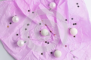 Pink pastel background. Christmas balls, pompons and glitter stars. simple flat lay composition