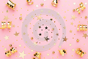 Pink pastel festive flatly. Many sparkling golden confetti and ribbons scattered at pink background. Festive concept