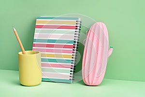 Pink pencil case notepad on green. Back to School