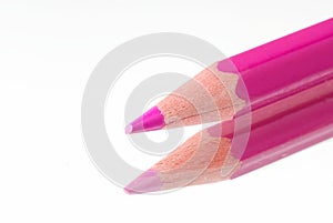 Pink pencil with reflection lies on a mirror