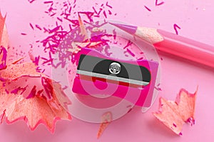 Pink pencil, sharpener and shavings on light background, flat lay