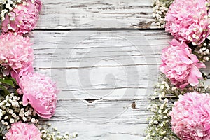 Pink Peonies and Babys Breath Flowers over a White Wooden Background