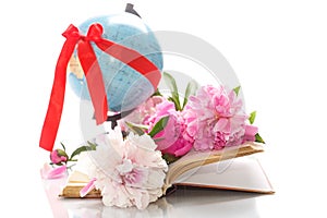 Pink peonies in the open book and globe