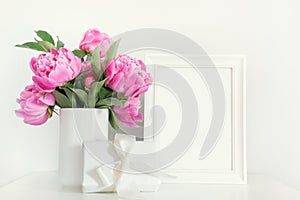 Pink peony in vase with gift photo frame on white. Mothers day