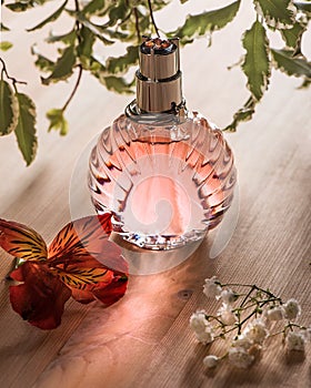 The pink perfume bottle on the nature wood background