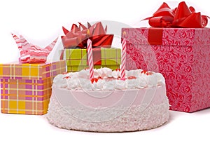 Pink pie with two candles and gifts in boxes