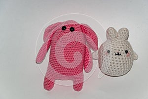 Pink pig and white bunny, hand-knitted, with black beady eyes.