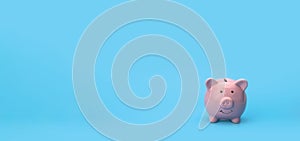 Pink piggy bank on blue background with copy space, saving and investing Financial management and bank