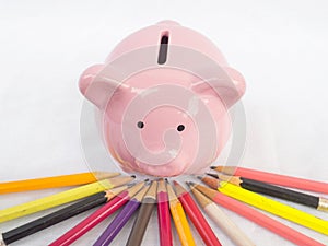 Pink piggy bank with Bright colored pencils, Saving money for future plan and retirement fund concept