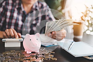 Pink piggy bank with business woman hand calculating expenses, saving money wealth and financial concept, finance, investment,