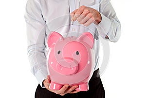 Pink piggy bank with businessman in the background