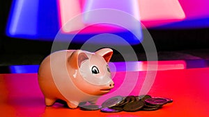 Pink piggy bank with coins and colorful background and copy space