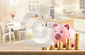 Pink piggy bank coins and modern kitchen interior in the background. Bank construction or insurance concept