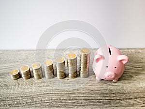 Pink piggy bank with coins pile growth graph, saving money for future investment plan and retirement fund concept