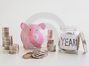 Pink Piggy bank with coins pile saving money in year one, Saving money for future plan and retirement fund concept