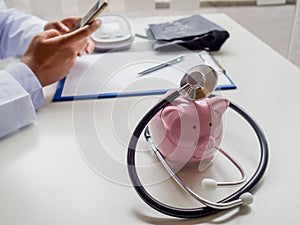 Pink piggy bank with doctor stethoscope and pressure gauge, Saving money for future plan and Health insurance concept