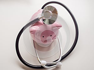 Pink piggy bank with doctor stethoscope, Saving money for future plan and Health insurance concept