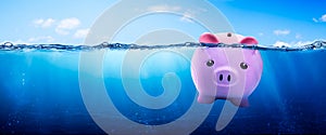 Pink Piggy Bank Drowning In Clear Blue Waters - Financial Debt