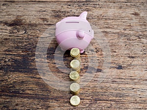 Pink piggy bank with gold coins pile growth graph, Saving money for future investment plan and retirement fund concept
