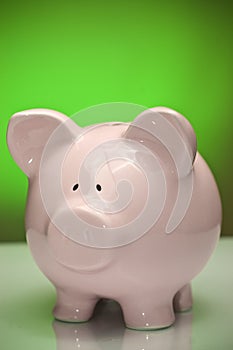 Pink piggy bank on green background