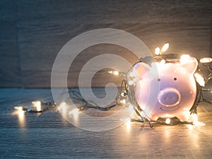 Pink piggy bank with Party lights, Enjoy savings for the holidays concept