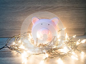 Pink piggy bank with Party lights, Enjoy savings for the holidays concept