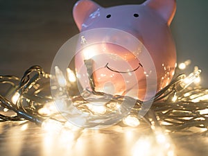 Pink piggy bank with Party lights, Enjoy savings for the holidays concept