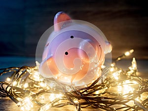 Pink piggy bank with Party lights, Enjoy savings for the holidays concept