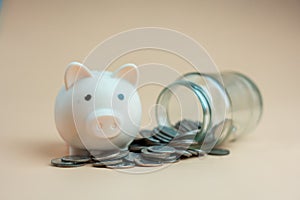 Pink piggy bank with a pile of coins from a glass bottle. Earning interest on savings