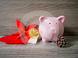 Pink piggy bank and pinecone with x`mas theme, Enjoy savings for the holidays concept