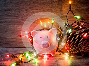 Pink piggy bank and pinecone with Party lights, Enjoy savings for the holidays concept